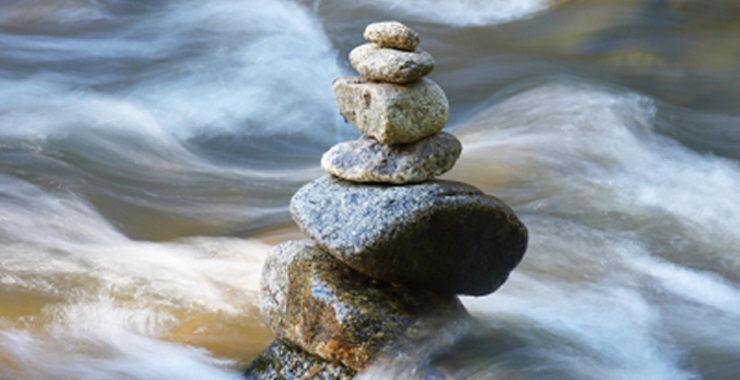 Rocks balanced on top of each other in a moving stream