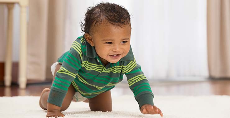 Happy baby crawling on the floor.