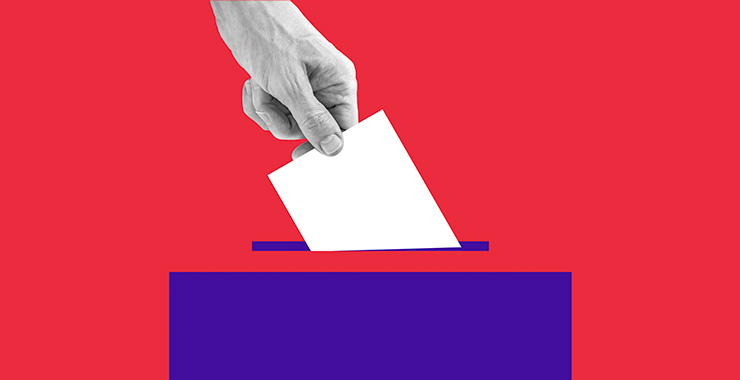 Image is of a hand putting a ballot into a box.