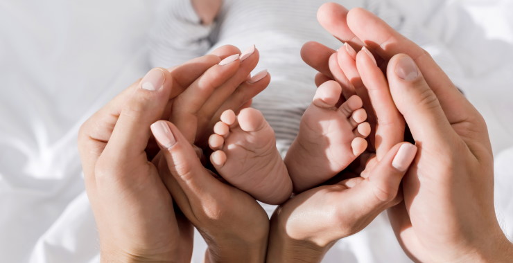 Hands embracing baby's feet