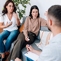 people sitting on a couch having a conversation