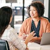two women talking at a computer