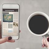 person holding cell phone and cup of coffee
