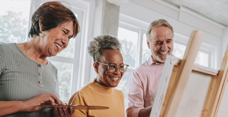 older adults enjoying art at easels