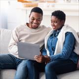 A couple on sofa sharing a laptop