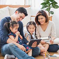 family sitting on the floor together looking happy
