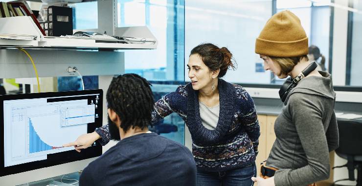 Young researchers viewing chart on computer screen