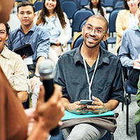 people sitting in chairs in a conference presentation setting