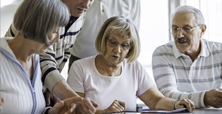 Group of seniors examine digital tablet