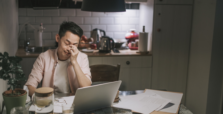 man sitting at a table in front of a laptop