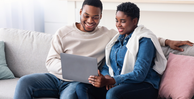 A couple on sofa sharing a laptop