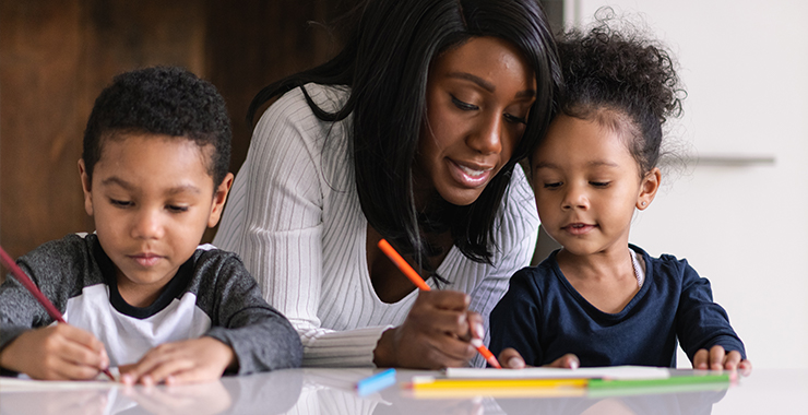 woman helping children with schoolwork