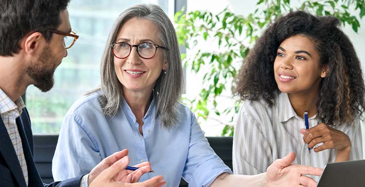 two women and a man talking.