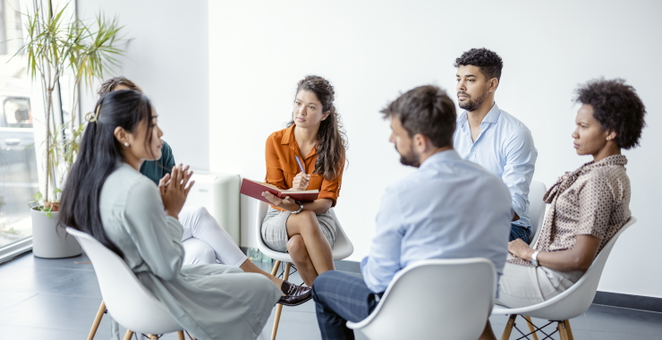 group of people sitting around in a circle conversing