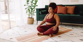 Woman practicing meditation at home.