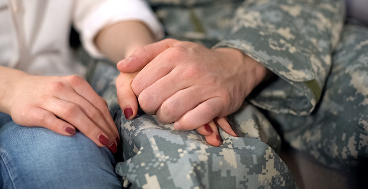 serviceman holding hands with spouse